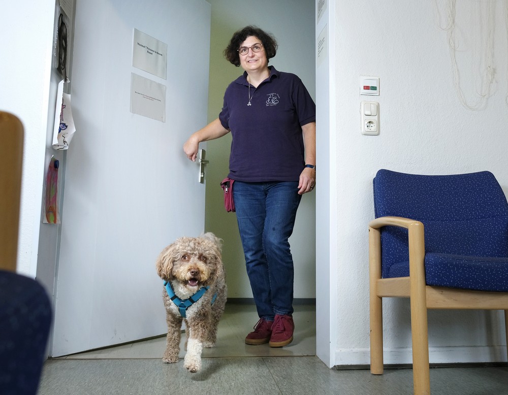 Tiertherapeutin Inge Hoster kommt mit Therapiehund Toffi zur Tür herein