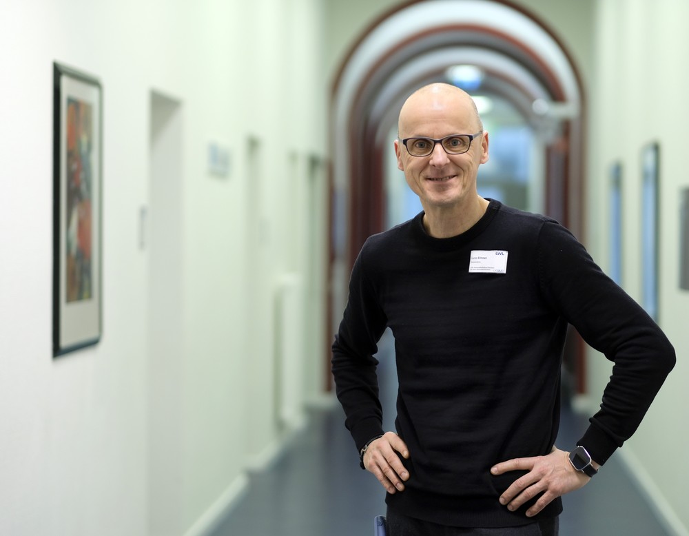 Mann steht in einem Krankenhausflur