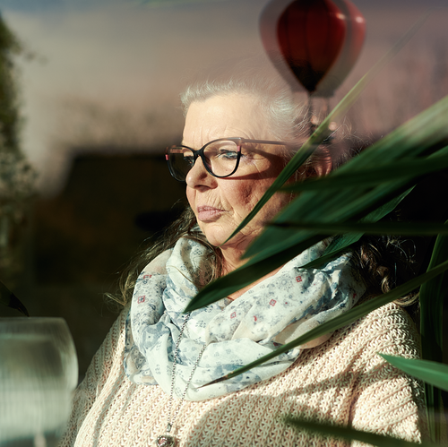 Eine Frau, die traurig aus aus dem Fenster sieht