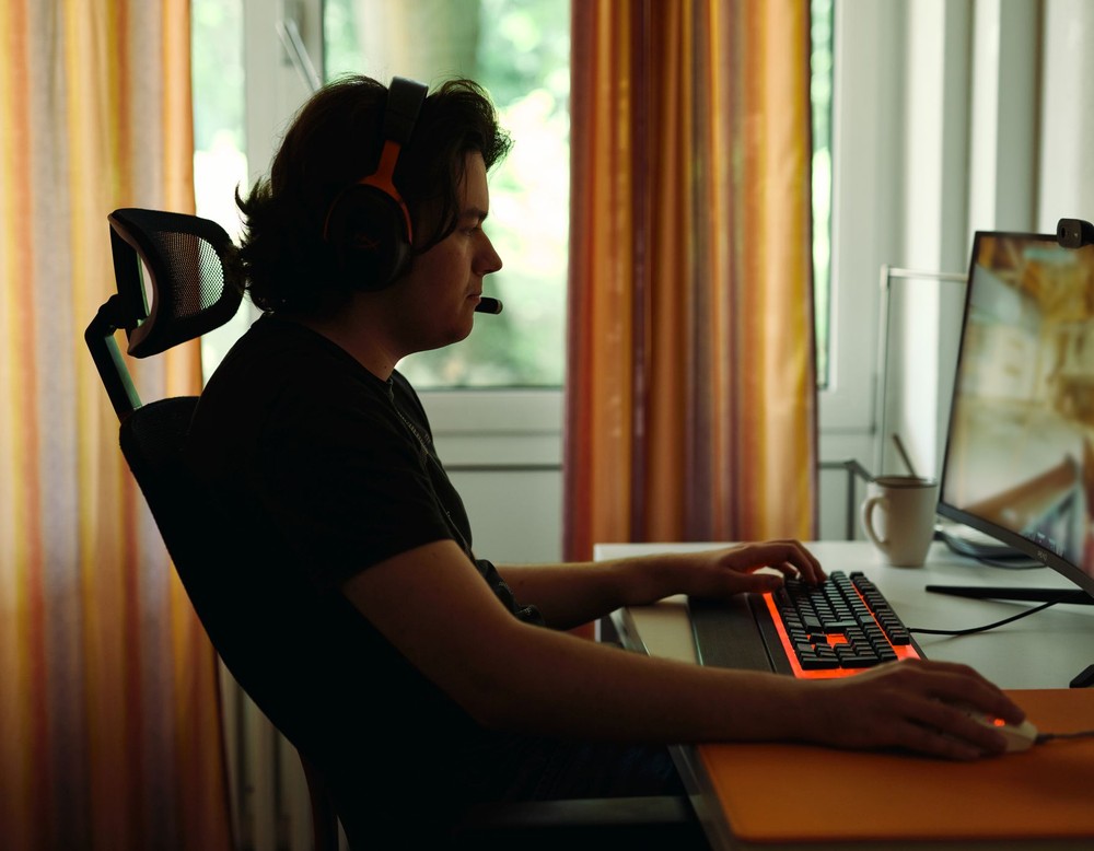 Ein Mann der an einem Schreibtisch sitzt und ein Computerspiel spielt.