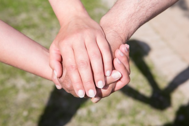 Drei Hände sternförmig übereinander gelegt