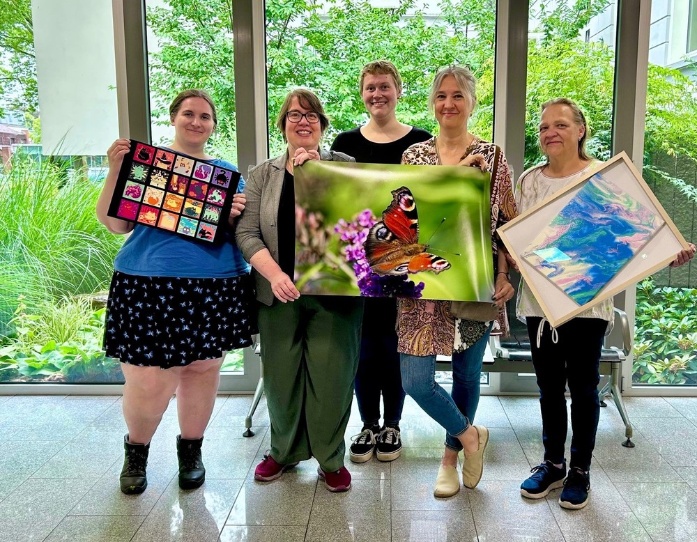Fünf Frauen halten Bilder in ihren Händen.