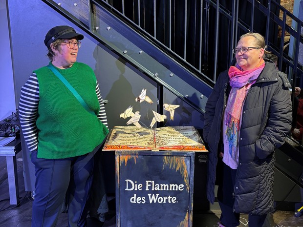 Zwei Personen stehen neben einer Skulptur