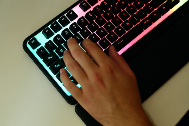 Hand liegt auf farbig beleuchteter Gaming-Tastatur