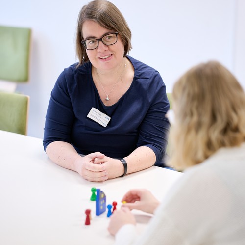 Zwei Frauen im Gespräch an einem Tisch