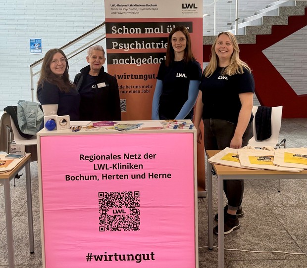 Gruppenfoto von 4 Personen an einem Messestand