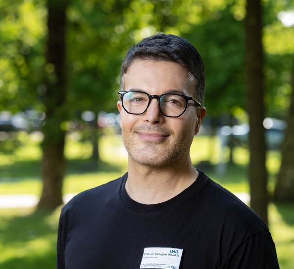 Ein Mann der in die Kamera lächelt.